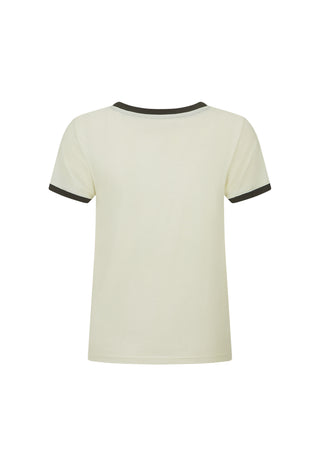 A woman wearing a cream ringer T-shirt with black trim and a vintage horse graphic on the front