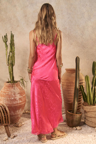 woman-in-a-pink-dress-standing-among-potted-cacti-and-terracotta-pots